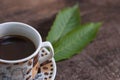 Hot coffee in the cup on old wood table with leaf Royalty Free Stock Photo