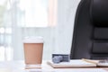 Hot coffee cup placing on manager desk together with stamp, book