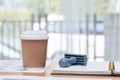 Hot coffee cup placing on manager desk together with stamp, book and document