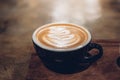 Hot coffee cup on table in cafe.Close up hot cappuccino coffee cup with latte art on wood table at cafe,food and drink Royalty Free Stock Photo