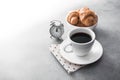 hot coffee cup with tasty croissant on stone table