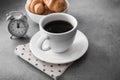 hot coffee cup with tasty croissant on stone table