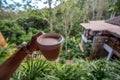 Hot Coffee in a Cup was holding by left hand in front of landscape mountain view Royalty Free Stock Photo