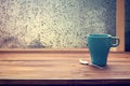 Hot coffee cup on wood table with raindrop window,