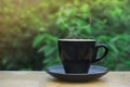 Hot coffee, heart shape smoke in black ceramic cup on wooden table in coffee shop and cafe with green background and flare light, Royalty Free Stock Photo