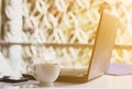 Hot coffee, Laptop and mobile on the table in bright morning