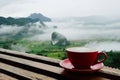 Hot coffee latte cappuccino in red cup on wooden terrace with be Royalty Free Stock Photo