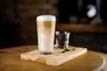Hot latte coffee in a high glass cup on a wooden board Royalty Free Stock Photo