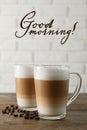 Hot coffee with milk in glass cups and beans on wooden table. Good morning Royalty Free Stock Photo