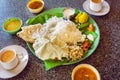 Hot coffee and plate with South Indian food thali with rice and spicy vegetables, on palm leaf in indian cafe. Royalty Free Stock Photo