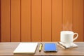 Hot coffee, smart phone, notebook and pen in wooden room Royalty Free Stock Photo