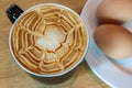 Hot coffee and soft focus of eggs on a wooden table background