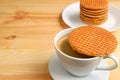 Hot Coffee with Stroopwafel Placed on Top of the Cup with Blurry  Stroopwafel Stack Royalty Free Stock Photo