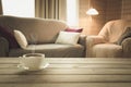 Hot coffee on tabletop in modern living room in rustic style. Blurred abstract background for design. Royalty Free Stock Photo