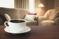 Hot coffee on tabletop in modern living room in rustic style with chair, soft divan. Royalty Free Stock Photo