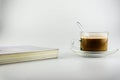 Hot coffee, tea on a saucer, transparent glass coffee cup with books by i