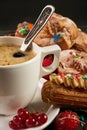 Hot coffee and a variety of berry french eclairs with currant Royalty Free Stock Photo