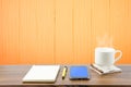 Hot coffee, smart phone, notebook and pen in wooden room Royalty Free Stock Photo