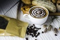 Hot coffee in white cup, with bakery and coffee beans in hemp bag, placed on white wood table, With sunshine in morning,Beauty Royalty Free Stock Photo