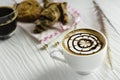 Hot coffee in white cup, with bakery and coffee beans in hemp bag, placed on white wood table, With sunshine in morning,Beauty Royalty Free Stock Photo