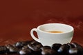 Hot coffee in a white coffee cup and many coffee beans placed around on wooden table Royalty Free Stock Photo