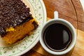 Coffee in white cup and piece of carrot cake with chocolate icing. Royalty Free Stock Photo