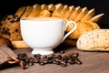 Hot coffee in white cup with smoke, with bakery and coffee beans in hemp bag placed on dark brown wood table,Beauty concept of Royalty Free Stock Photo