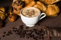 Hot coffee in white cup with smoke, with bakery and coffee beans in hemp bag placed on dark brown wood table,Beauty concept of Royalty Free Stock Photo