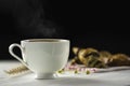 Hot coffee in white cup, with smoke and bakery placed on white wood table, dark background With sunshine in morning,Beauty concept Royalty Free Stock Photo