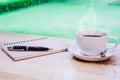 Hot Coffee on white cup with smoke,work desk with pen and notebook Royalty Free Stock Photo