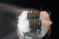 Hot coils steaming in rda vaping with black background