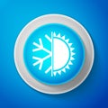 Hot and cold symbol. Sun and snowflake icon isolated on blue background. Winter and summer symbol. Circle blue button