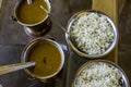 Hot and cooked pulse and rice served in steel vessels on glass table Royalty Free Stock Photo