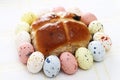 Hot cross bun surrounded by Speckled easter eggs Royalty Free Stock Photo