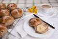 Hot cross buns on cooling tray with one cut and buttered Royalty Free Stock Photo