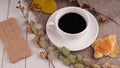 A hot cup of coffee with a bar of chocolate on the table in a cafe. Composition of a delicious coffee and sweet snack. Royalty Free Stock Photo