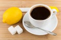 Hot cup of coffee, lemon, knife, spoon and sugar