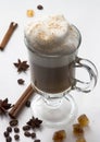 Hot Cup of coffee with whipped milk foam on the white background with cinnamon sticks, stars of anise and Royalty Free Stock Photo