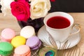 Hot cup of red tea and colored cakes Royalty Free Stock Photo