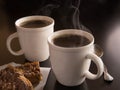 Hot cups of coffee with danish on dark background
