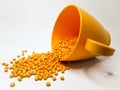 hot cut type orange masterbatch granules on same colored plastic cup, isolated white background Royalty Free Stock Photo