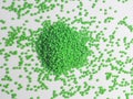 Hot cutting type green masterbatch granules on white background, masterbatch is used as product colorant in plastic industry
