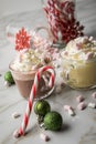 Hot dark chocolate during holiday season with whipped cream, marshmallows, candy canes, Christmas tree ornaments, green glitter Royalty Free Stock Photo