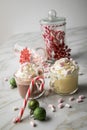 Hot dark chocolate during holiday season with whipped cream, marshmallows, candy canes, Christmas tree ornaments, green glitter Royalty Free Stock Photo