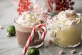 Hot dark chocolate during holiday season with whipped cream, marshmallows, candy canes, Christmas tree ornaments, green glitter Royalty Free Stock Photo