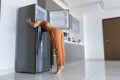 On a hot day, the girl cools with his head in the refrigerator. Broken air conditioner Royalty Free Stock Photo