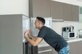 On a hot day, the guy cools with his head in the refrigerator. Broken air conditioner Royalty Free Stock Photo