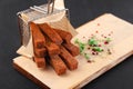 Hot deep-fried dark bread sticks, scattered from grid