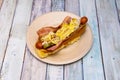 Hot dog with brioche bread, melted cheese, pickled gherkins