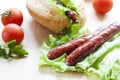 Hot dog. Grilled hot dogs with fresh salad lettuce on wooden table. Royalty Free Stock Photo